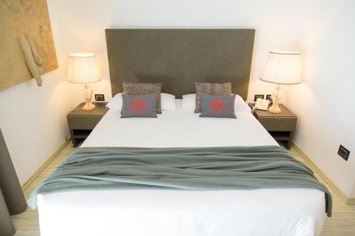 a bedroom with a large white bed with two lamps at Hotel San Giacomo Spa&Gourmet in Brentonico