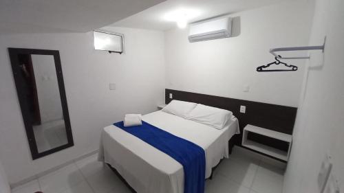 a small bedroom with a bed and a mirror at Casa da Lalá in Fortaleza