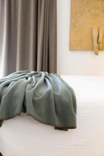 a blanket sitting on a bed next to a curtain at Hotel San Giacomo Spa&Gourmet in Brentonico