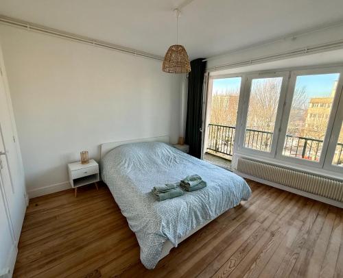 une chambre avec un lit et une grande fenêtre dans l'établissement La Criée, un balcon sur le port, à Boulogne-sur-Mer