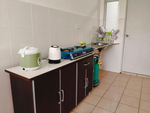 a kitchen with a stove and a counter top at Serene Homestay in Tawau