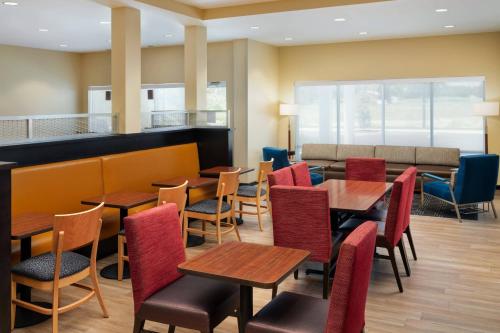 a restaurant with tables and chairs and a bar at TownePlace Suites by Marriott Leesburg in Leesburg