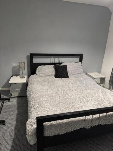 a bedroom with a large bed with a black headboard at Make It Your Home in Wednesfield