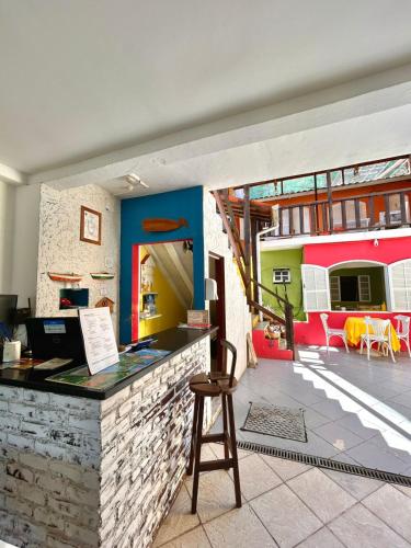 a restaurant with a bar with a stool in front at Nova Aldeia Buzios in Búzios