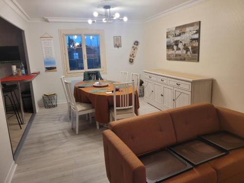 - un salon avec un canapé et une table à manger dans l'établissement GITE MAISON 3 P prox le mans circuit et zoo la fleche a 18kms, à La Suze-sur-Sarthe