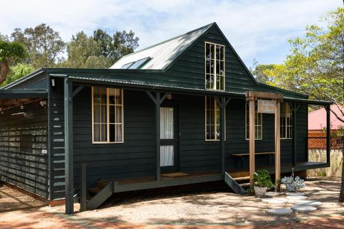 a black house with a gambrel roof at Seahorse Manor, The South Coast Sandcastles in Huskisson