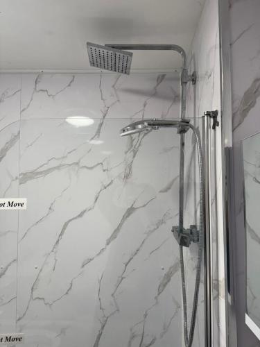 a bathroom with a shower with white marble at Make It Your Home in Wednesfield