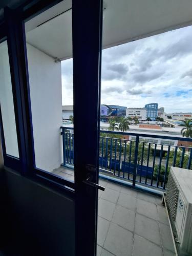 a door to a balcony with a view of the ocean at King of kings at SEA RESIDENCES in Manila