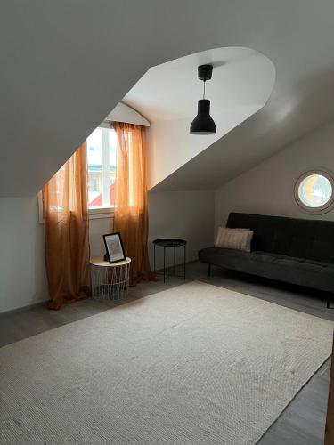 a living room with a black couch and a window at Apartment Klemetti in Vaasa