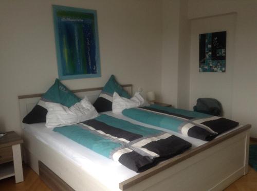a bedroom with a bed with blue and white pillows at Haus Weiherfeld in Tholey