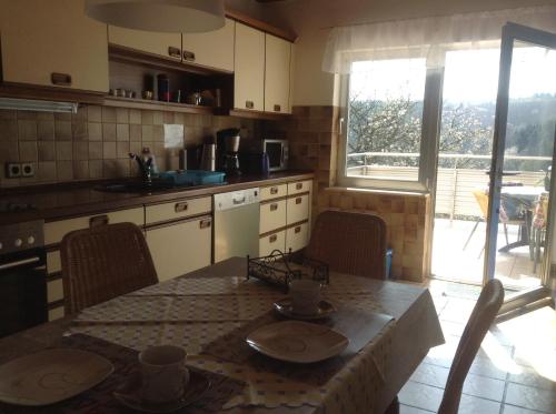 a kitchen with a table and chairs and a table and a table and a kitchen at Haus Weiherfeld in Tholey