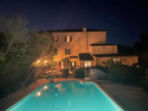une piscine devant une maison la nuit dans l'établissement l escapade Corbières, à Lagrasse