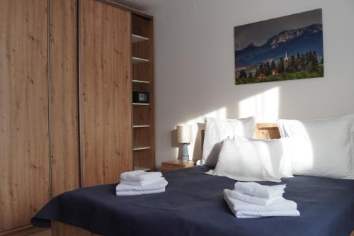 ミエルクレア・チュクにあるOrgona Apartmentsのタオルが敷かれたベッドのある寝室