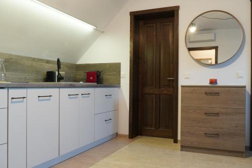 ミエルクレア・チュクにあるOrgona Apartmentsの白いキッチン(シンク、鏡付)