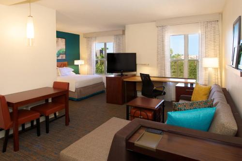 a hotel room with a bed and a living room at Residence Inn by Marriott Phoenix Airport in Phoenix