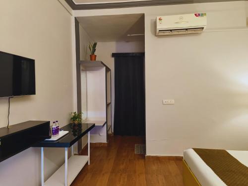a room with a bed and a television and a table at Elephant Pushkar in Pushkar