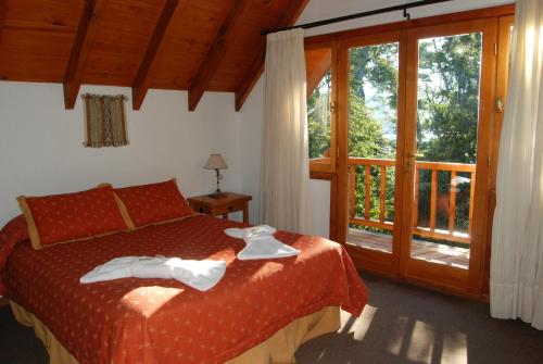 a bedroom with a bed and a sliding glass door at Melewe in Villa La Angostura