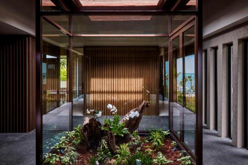 a glass hallway with a garden in the middle at The Ritz-Carlton, Langkawi in Pantai Kok