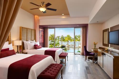 a hotel room with two beds and a balcony at Secrets Vallarta Bay Resort & SPA - Adults Only in Puerto Vallarta