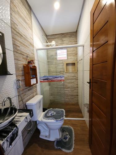 a small bathroom with a toilet and a shower at Pousada Brisa das Dunas in Paulino Neves