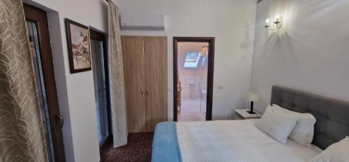 a bedroom with a white bed and a bathroom at Opus Villa in Sinaia