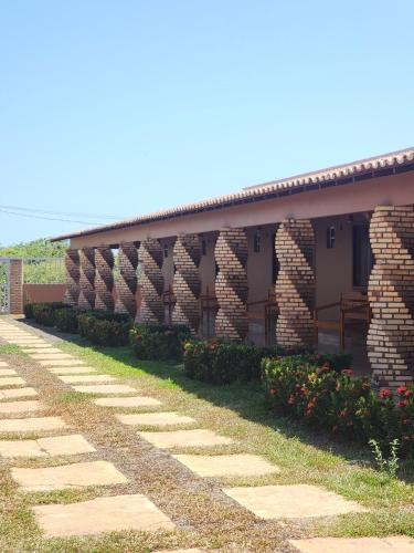 a brick building with a pathway in front of it at Pousada Brisa das Dunas in Paulino Neves