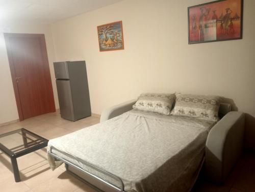 a small bedroom with a bed and a refrigerator at LA MIA BELLA GRAVINa in Gravina in Puglia