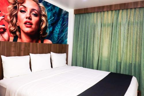 a bedroom with a bed with a poster of a woman at Yours Hotel Lifestyle in Chiclayo