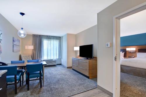a hotel room with a bed and a desk with a television at TownePlace Suites by Marriott Panama City Beach Pier Park in Panama City Beach