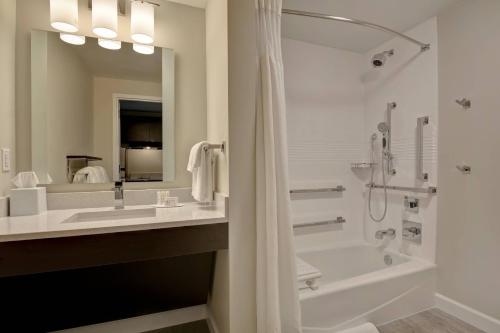 a bathroom with a tub and a sink and a shower at TownePlace Suites by Marriott Panama City Beach Pier Park in Panama City Beach
