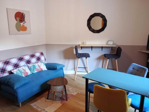 un salon avec un canapé bleu et une table dans l'établissement Le Mont-Dore - Agréable T2 bis avec wifi - FR-1-608-246, à Le Mont-Dore