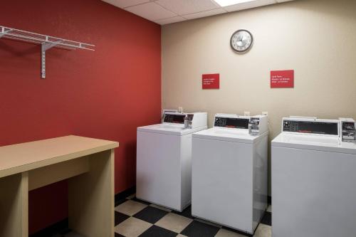 a room with three washing machines and a clock on the wall at TownePlace Suites by Marriott Panama City in Panama City