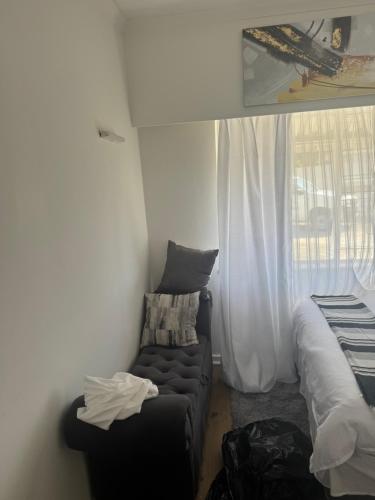 a living room with a couch and a window at Willow Rose in Gqeberha