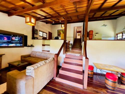 un salon avec un canapé et un escalier dans l'établissement Casa da Mel, à Itatiaia