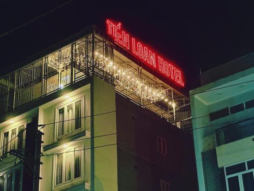 a building with a neon sign on top of it at Khách Sạn Tiến Loan in Hòa Bình