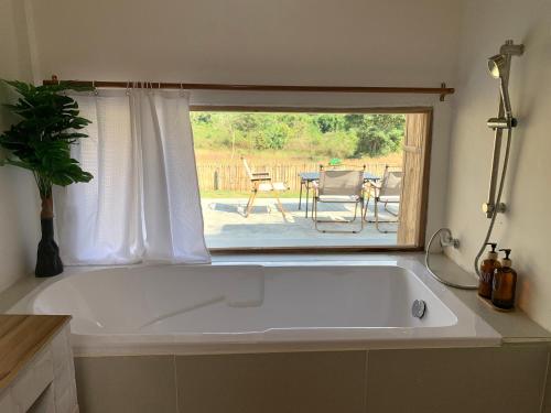 a large white bath tub in a kitchen with a patio at อาเลเล พูลวิลล่า ahlaylay pool villa in Ban Ku Phadu