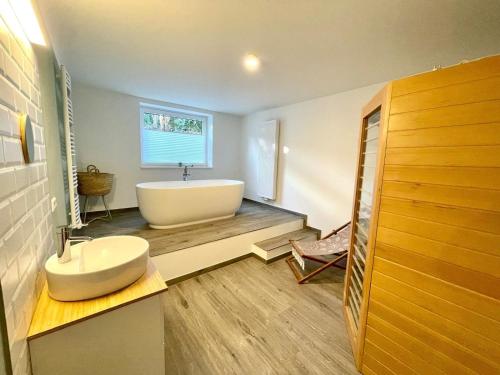 a bathroom with a large white tub and a sink at Wohlfühloase in Windeby