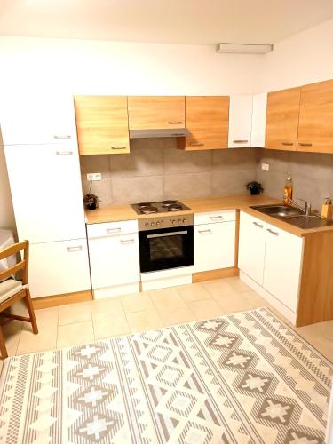 a kitchen with white cabinets and a stove top oven at Family Apartments Tauchen in Mönichkirchen