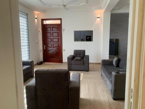 a living room with two couches and a brown door at Bonvilla in Accra