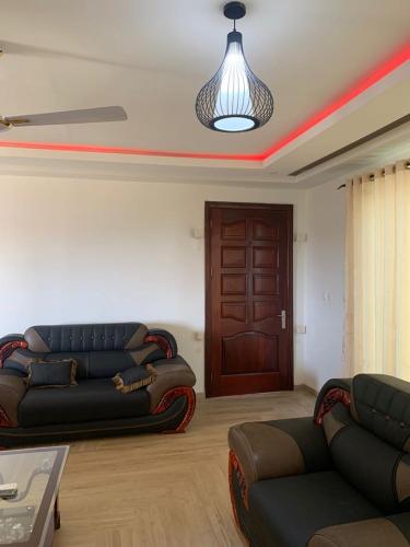 a living room with two couches and a wooden door at Bonvilla in Accra