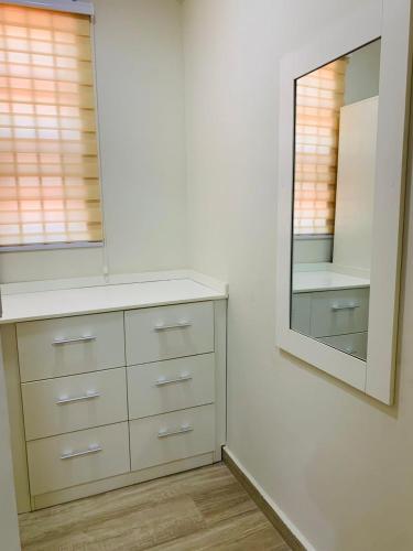 a bathroom with a dresser and a mirror at Bonvilla in Accra