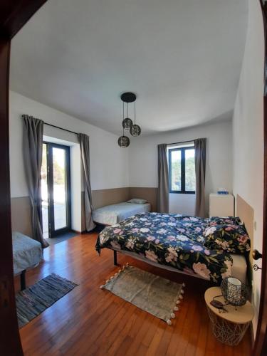 a bedroom with a bed and two windows at Casa branca in Porto Carvoeiro