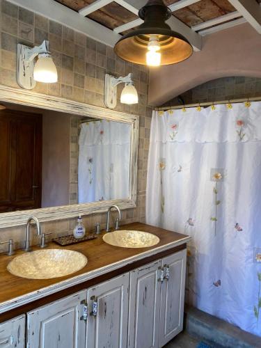a bathroom with two sinks and a mirror at Casitas El Lago in Carhué