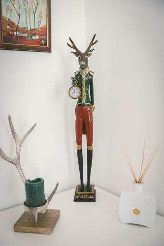 a statue of a deer with a clock on a table at "Hunter's Suite"- at the heart of Hartberg I Parking in Hartberg