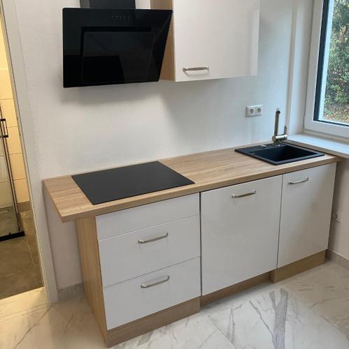 a kitchen with a counter with a sink and a microwave at Apartments Y Edelhof in Saalfeld