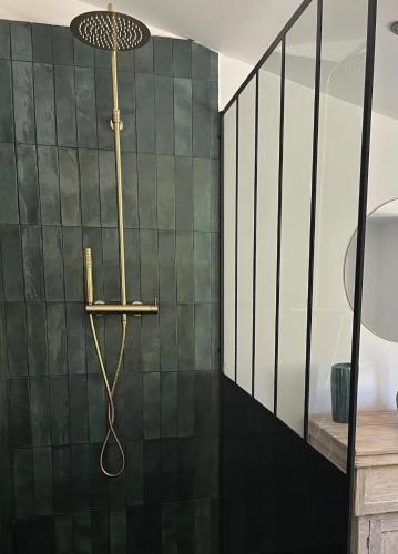 La salle de bains est pourvue d'une douche et de carrelage vert. dans l'établissement Maison de ville avec piscine, à Châteaurenard