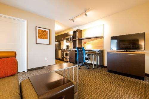 a living room with a couch and a table and a kitchen at TownePlace Suites by Marriott Portland Beaverton in Beaverton