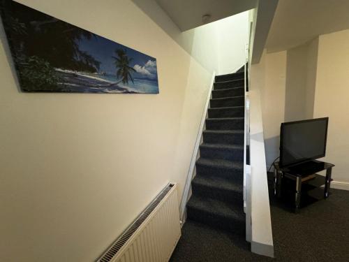 a hallway with a staircase with a tv on the wall at Double bed D3 Greater Manchester in Manchester