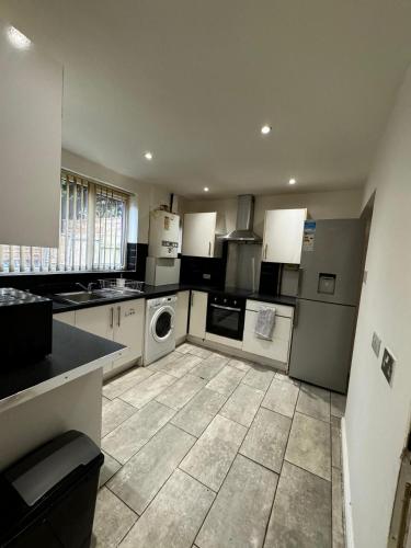 a kitchen with white appliances and a tile floor at Double bed D3 Greater Manchester in Manchester