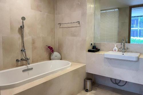 a bathroom with a bath tub and a sink at Baan Mai Khao Condo Phuket for rent in Phuket